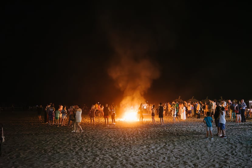 Gente alrededor de la hoguera en la playa para el popular festival del día de San Juan en el solsticio de verano, en Málaga, España.