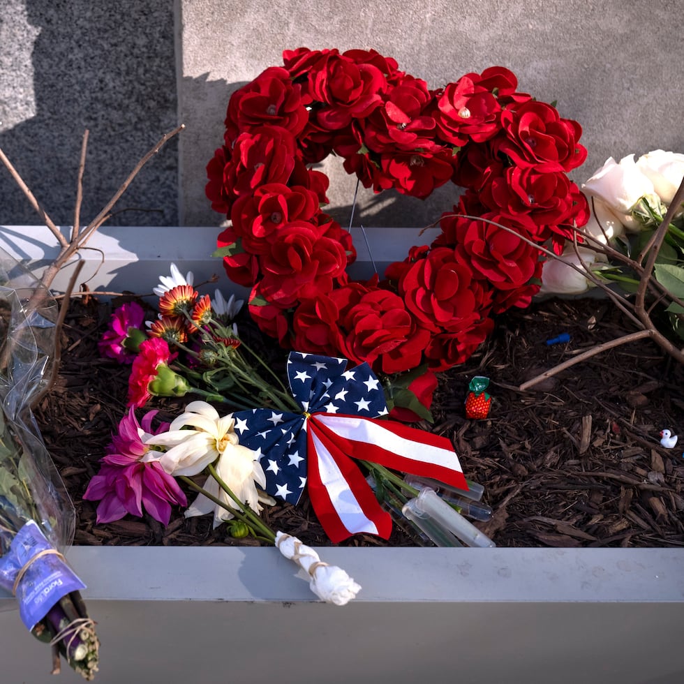 Un pequeño monumento hecho con banderas, flores y otros objetos en una jardinera, el viernes 28 de noviembre de 2025, cerca del sitio donde dos miembros de la Guardia Nacional fueron tiroteados en Washington.