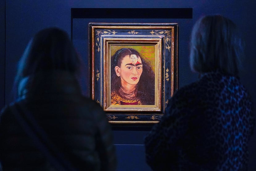 ARCHIVO - Los visitantes observan la pintura de Frida Kahlo titulada "Diego y yo", expuesta en la casa de subastas Sotheby's durante una presentación para la prensa en Nueva York.