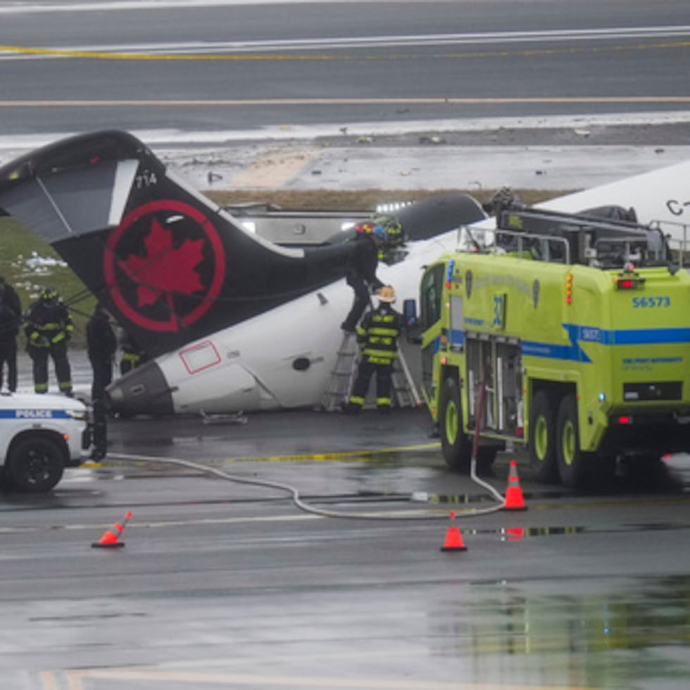 Bomberos e investigadores examinan el lugar, el lunes 23 de marzo de 2026, donde un avión de Air Canada se detuvo tras colisionar con un camión de bomberos de la Autoridad Portuaria en el aeropuerto de LaGuardia, después de aterrizar el domingo por la noche en Nueva York. (AP Photo/Seth Wenig)