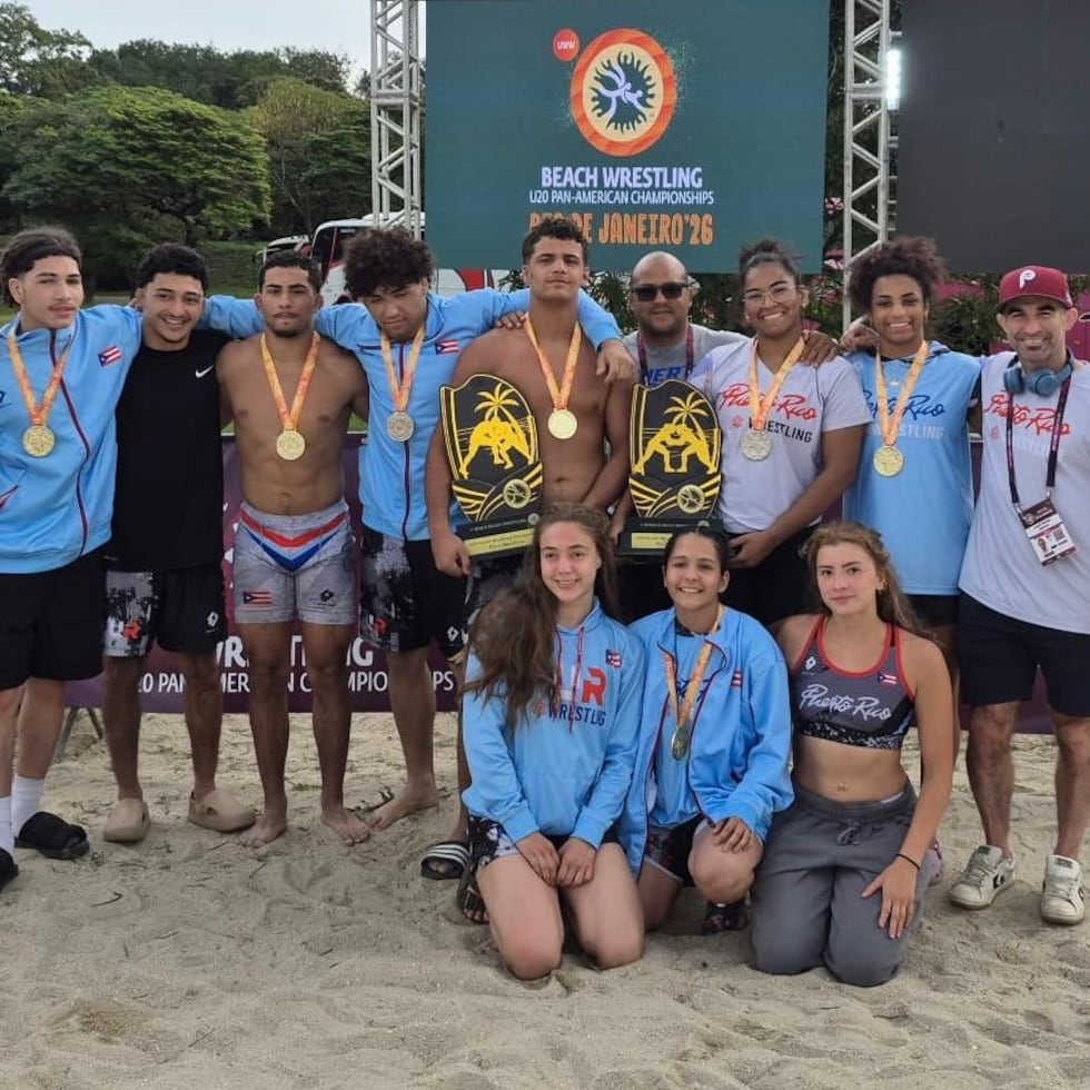 Los equipos de lucha libre de playa muestran sus trofeos y medallas.