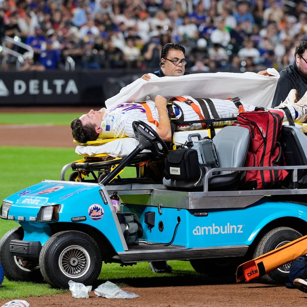 El primera base de los Mets de Nueva York Jared Young es sacado del terreno tras golpearse con el lanzador Nolan McLean durante el juego contra los Phillies de Filadelfia.