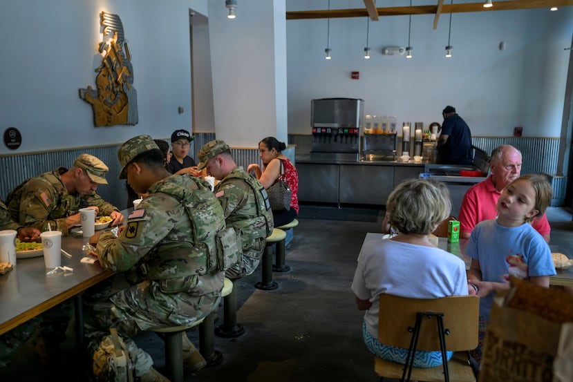 Miembros de la Guardia Nacional de Arkansas hacen una pausa para almorzar en el barrio de Columbia Heights, el martes 11 de agosto de 2026, en Washington. (AP Foto/Rod Lamkey, Jr.)