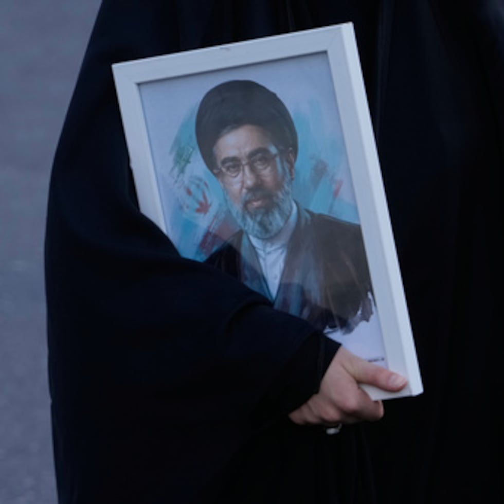 Una mujer sostiene una foto del líder supremo iraní, el ayatolá Mojtaba Jamenei.