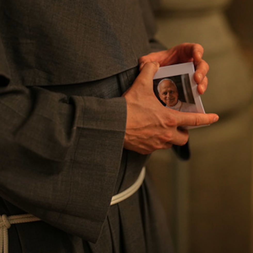 Padre Andrew sostiene una fotografía del papa León XIV.