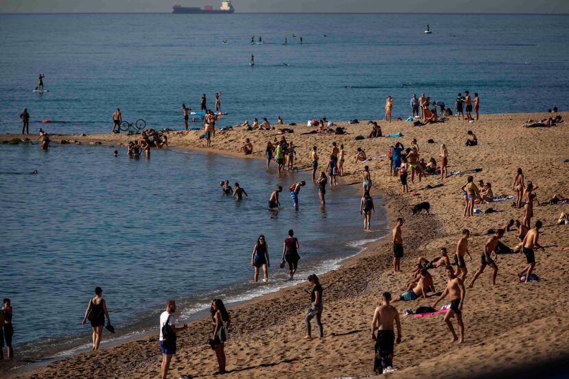 Cientos de personas asistieron a las playas de Barcelona durante su apertura. (AP)