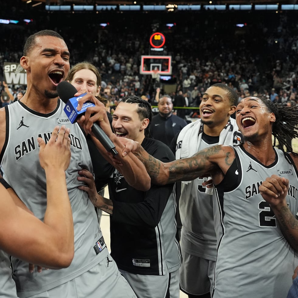 El delantero de los Spurs de San Antonio, Victor Wembanyama (centro), celebra con sus compañeros tras anotar el canasto de la victoria contra los Suns de Phoenix en los segundos finales