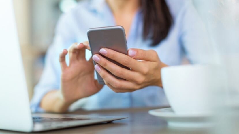 Una mujer sostiene su celular.