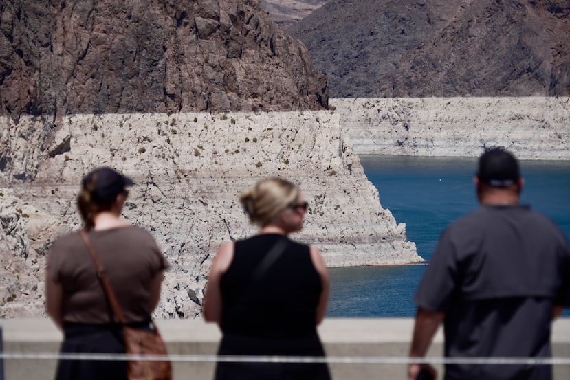 Turistas en la presa Hoover observan el anillo de minerales que forma una especie de bañera, el cual muestra los niveles de agua anteriores del lago Mead cerca de Boulder City, Nevada, el viernes 7 de agosto de 2026. (Foto AP/Ty ONeil)