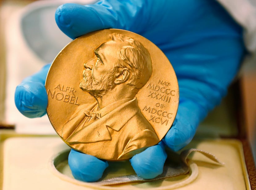 En esta imagen de archivo, un empleado de la biblioteca nacional muestra una medalla de oro del Premio Nobel.