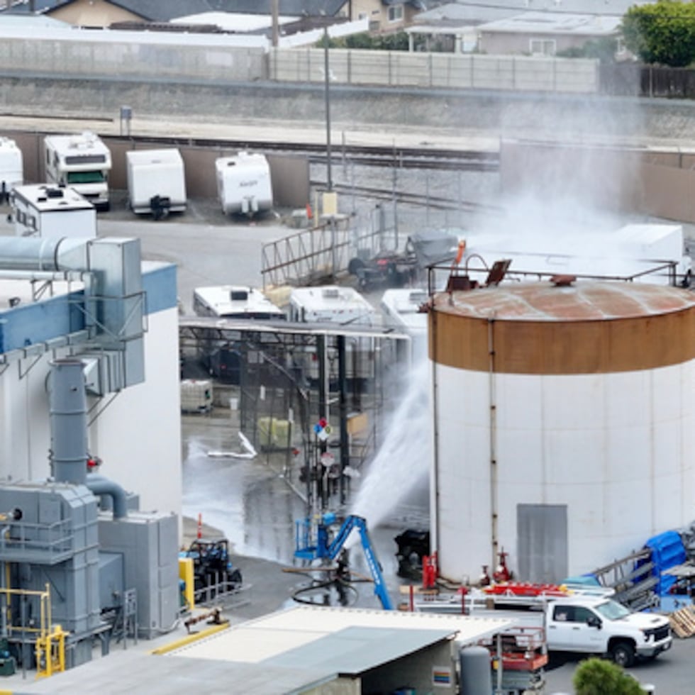 Se rocía agua sobre un tanque que se sobrecalentó en una planta aeroespacial en Garden Grove, California, el viernes 22 de mayo de 2026. (Jeff Gritchen/The Orange County Register vía AP)