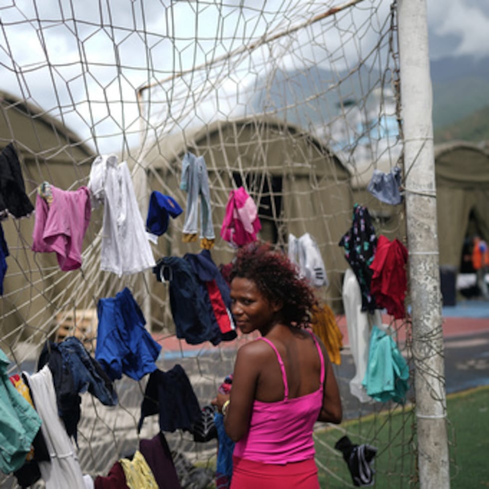 Nataly Mayora cuelga la ropa en una portería mientras lava la ropa en un complejo deportivo que hace las veces de albergue para personas desplazadas por los terremotos, el jueves 9 de julio.