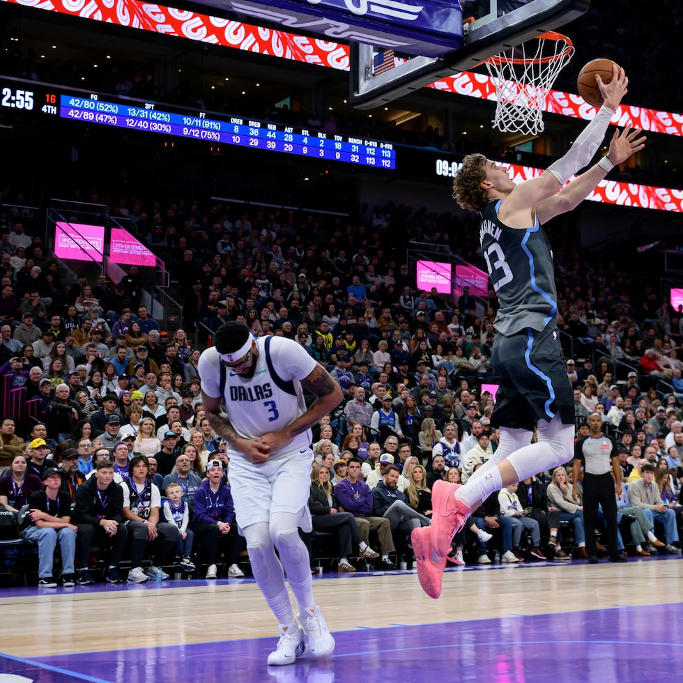 Lauri Markkanen, centro, del Jazz de Utah, encesta con una bandeja, mientras Anthony Davis, izquierda, de los Mavericks de Dallas, sufre una lesión en la mano durante la acción durante la segunda mitad del partido de baloncesto de la NBA, el jueves 8 de enero de 2026, en Salt Lake City. (AP Foto/Tyler Tate)
