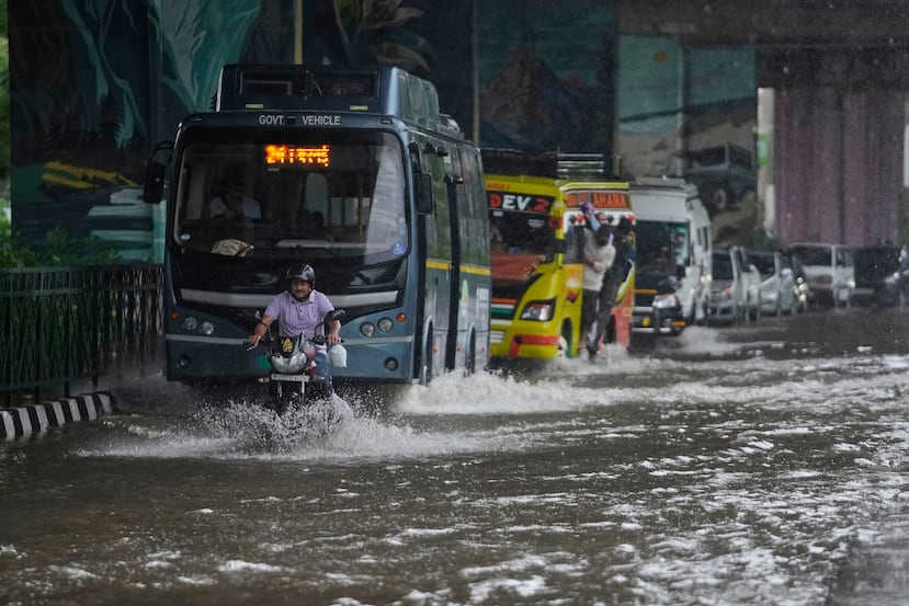 Commuters move through a flooded road after heavy rain in Jammu, India, Tuesday, Aug. 26, 2025.(AP Photo/Channi Anand)