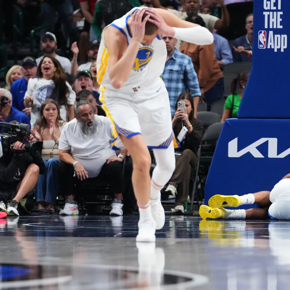Kristaps Porzingis, centro, y guard Gary Payton II, izquierda, de los Warriors de Golden State, reaccionan después de que Moses Moody (4) sufriera una lesión y se quedara tendido en la cancha.