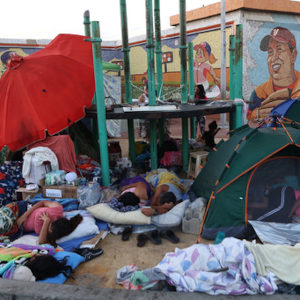 Personas cuyas casas resultaron dañadas por los terremotos duermen a la intemperie frente a un estadio de béisbol en Catia La Mar, Venezuela.