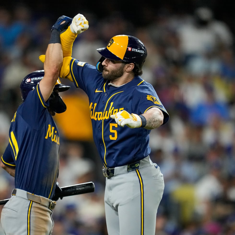 Garrett Mitchell (derecha) celebra su cuadrangular Cooper Pratt en la sexta entrada.