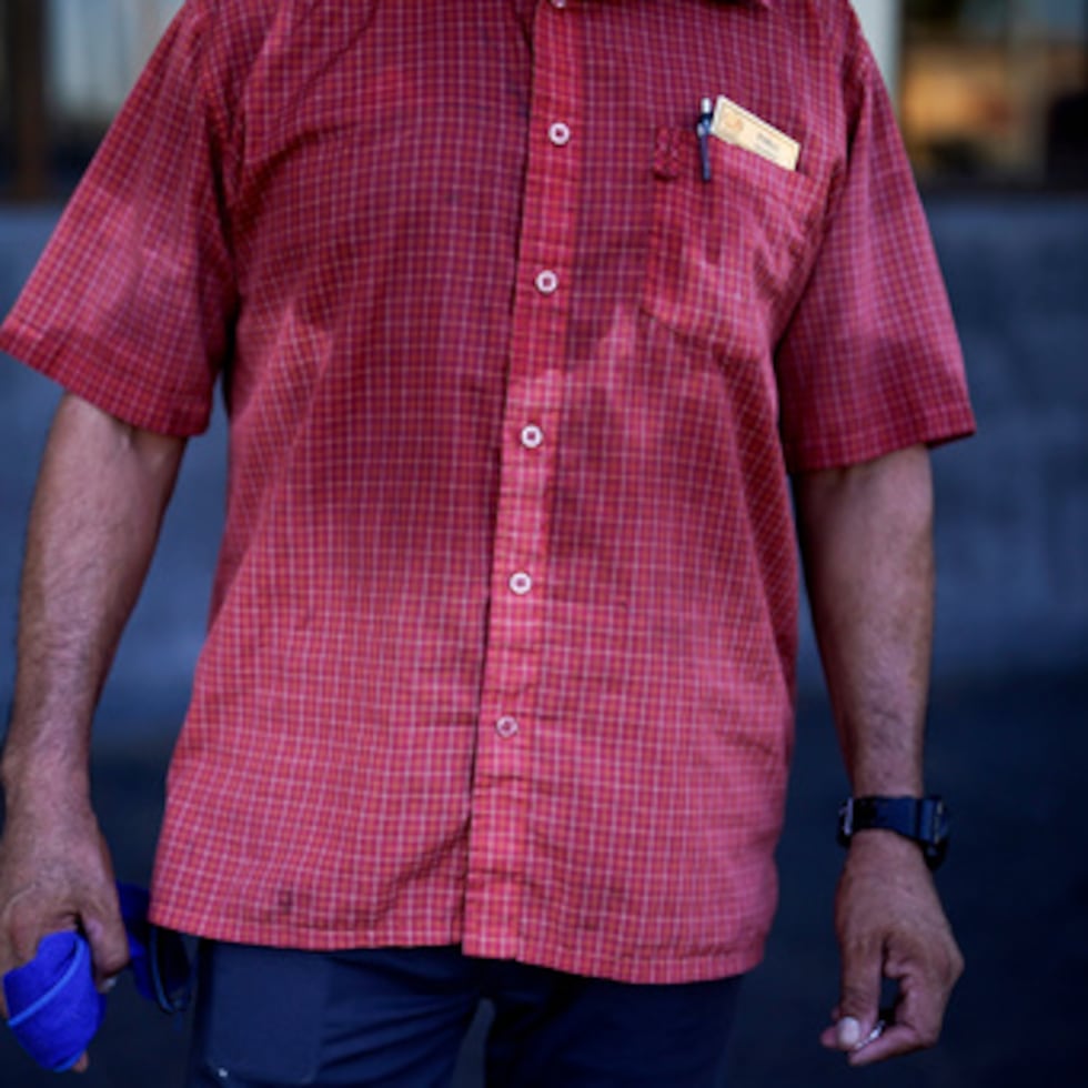 ARCHIVO - La camisa de un hombre está empapada de sudor antes de las siete de la mañana mientras aparca coches y se encarga de la seguridad de una cafetería del centro de la ciudad el 20 de julio de 2023, en Mexicali, México. (Foto AP/Gregory Bull, archivo)