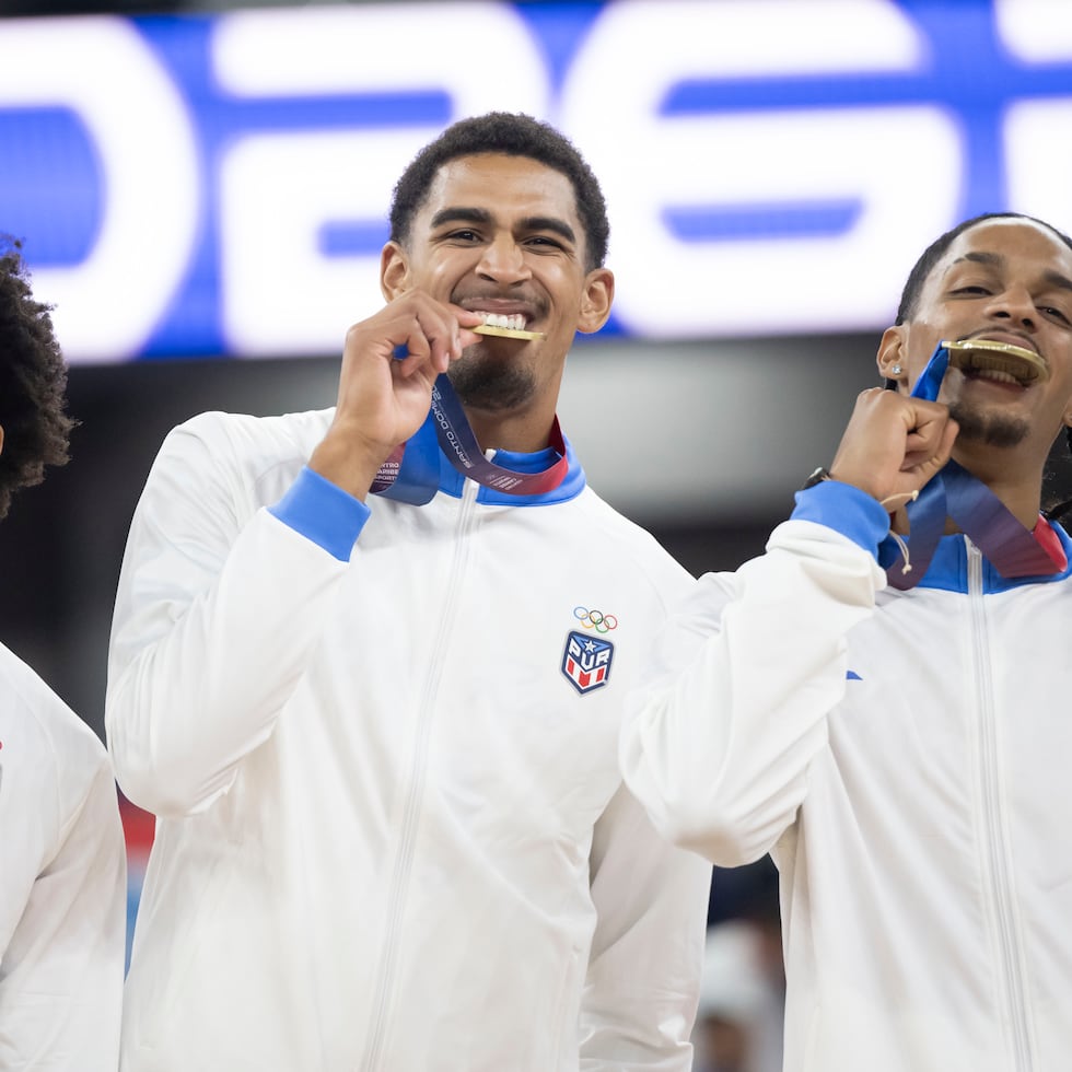 Los jugadores de Puerto Rico hacen la tradicional celebración de morder la medalla.