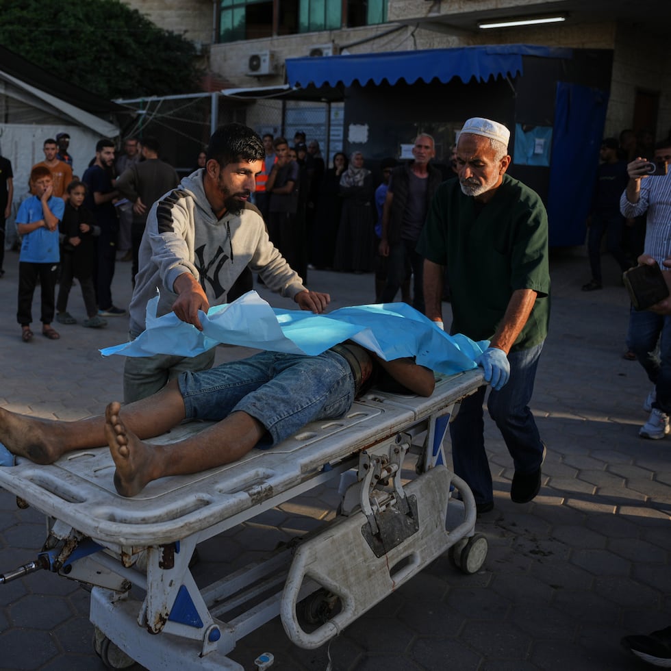 Palestinos trasladan el cuerpo de un hombre que murió por ataques israelíes en la Franja de Gaza a la morgue del Hospital Al-Aqsa en Deir al-Balah, el sábado 22 de noviembre de 2025.