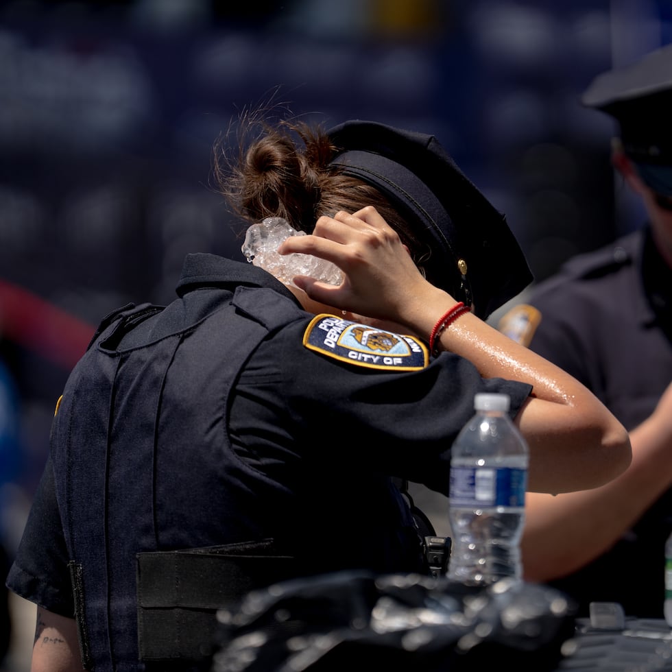 Un agente de policía se aplica hielo en el cuello para intentar refrescarse tras el concurso de comer perritos calientes Nathan's Famous del 4 de julio de 2026 en Coney Island, en el distrito de Brooklyn, Nueva York.