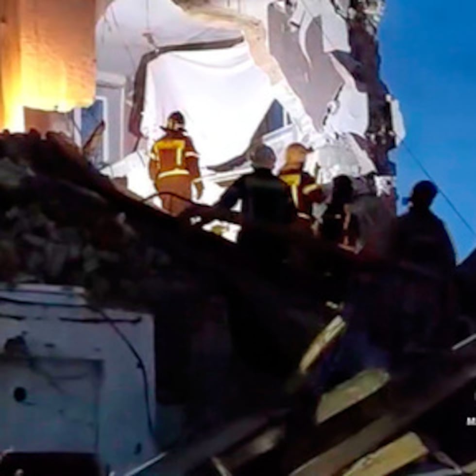 En esta foto proporcionada por el Servicio de Prensa del Ministerio de Emergencias de Rusia, los empleados del Ministerio de Emergencias de Rusia trabajan en el lado del edificio de apartamentos de varios pisos dañado alcanzado por un avión no tripulado ucraniano en Syzran en la región rusa de Samara.