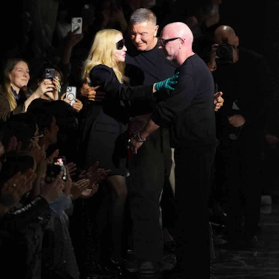Madonna felicita a Domenico Dolce, a la derecha, y Stefano Gabbana al final de la Dolce & Gabbana Otoño / Invierno 2026-2027 colección de la Mujer, presentado en Milán, Italia, sábado, 28 de febrero de 2026. (AP Photo/Antonio Calanni)
