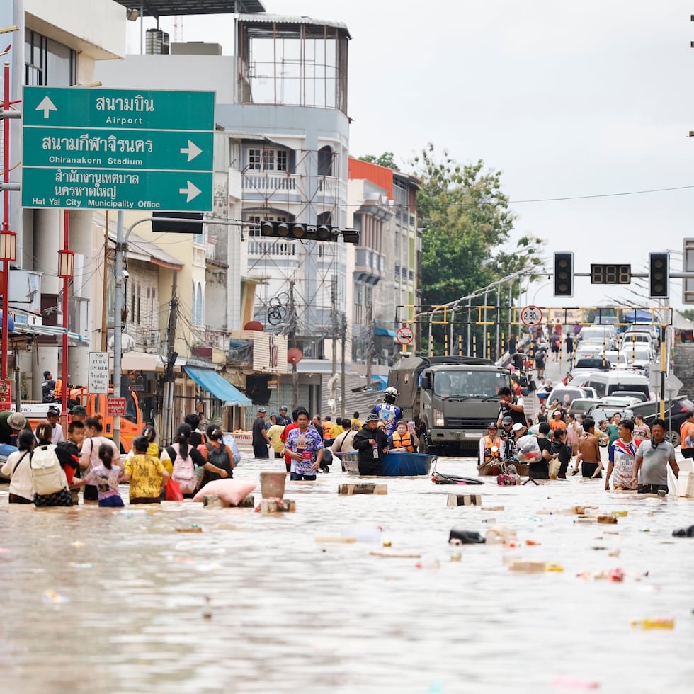 Gente camina entre las aguas inundadas en la provincia de Songkhla, en el sur de Tailandia, el jueves 27 de noviembre de 2025.