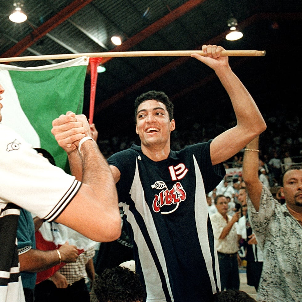Víctor “Vitito” Rivera felicita a Héctor “Picky” Soto, quien sostiene una bandera de San Sebastián, durante la final de 1999 en la cancha Pepín Cestero.