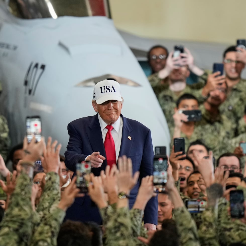 Soldados estadounidenses saludan y toman fotos con sus teléfonos al presidente Donald Trump a su llegada al portaaviones USS George Washington en la base del Ejército estadounidense en Yokosuka, en el sur de Tokio.
