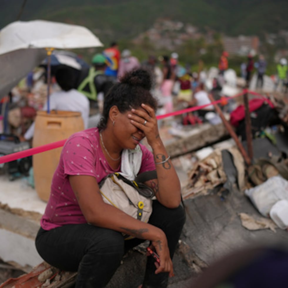 Khaterine Roa llora mientras los miembros del Cuerpo de Bomberos del Condado de Los Ángeles buscan supervivientes en un edificio que se derrumbó durante los terremotos que sacudieron La Guaira, Venezuela.