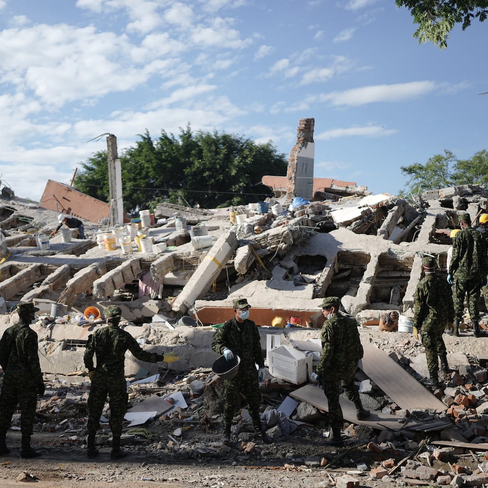 Soldiers clear debris three days after an earthquake struck Cali, Colombia, Thursday, Aug. 13, 2026. (AP Photo/Ivan Valencia)