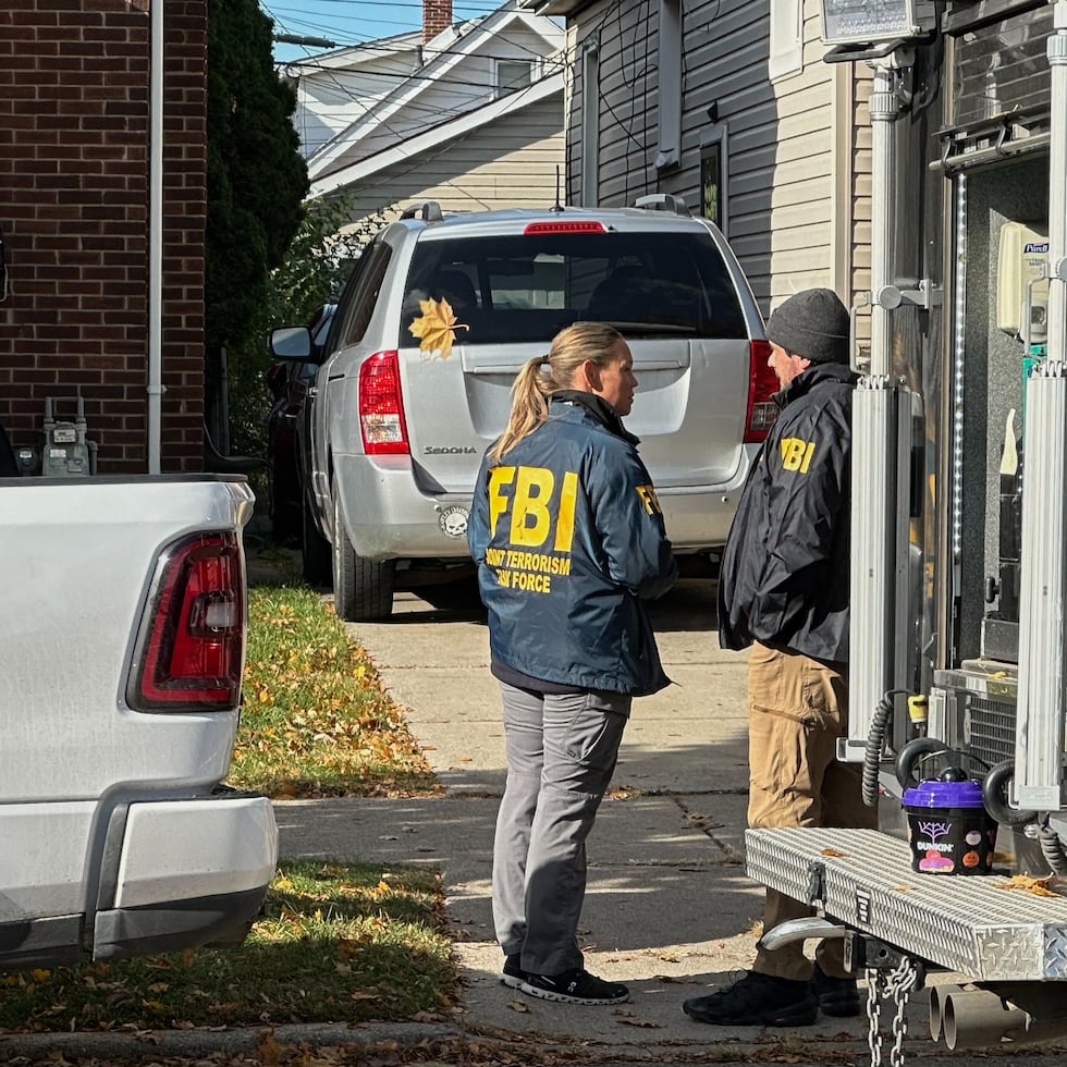 Agentes del FBI se reúnen frente a una casa en un vecindario de Dearborn, Michigan.