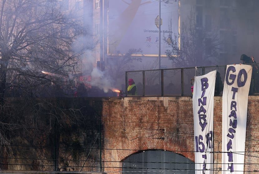 A demonstrator fires a flare during a protest against the Milan Cortina Winter Olympics and the presence of U.S. Immigration and Customs Enforcement agents, in Milan, Italy, Saturday Feb. 7, 2026. (Claudio Furlan/LaPresse via AP)