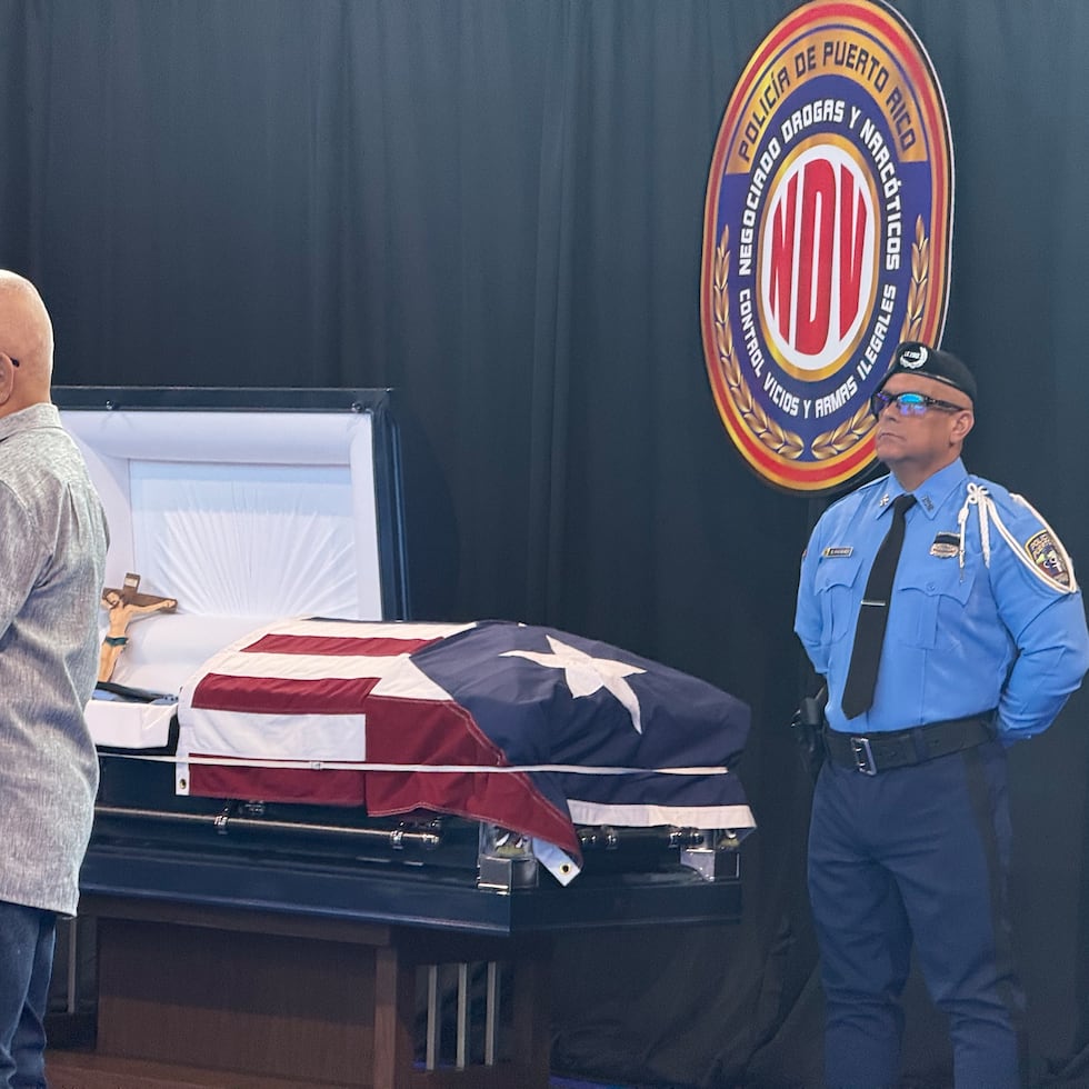 Un agente de la Policía realiza una guardia de honor junto al férretro del agente Eddie Santiago Renta.