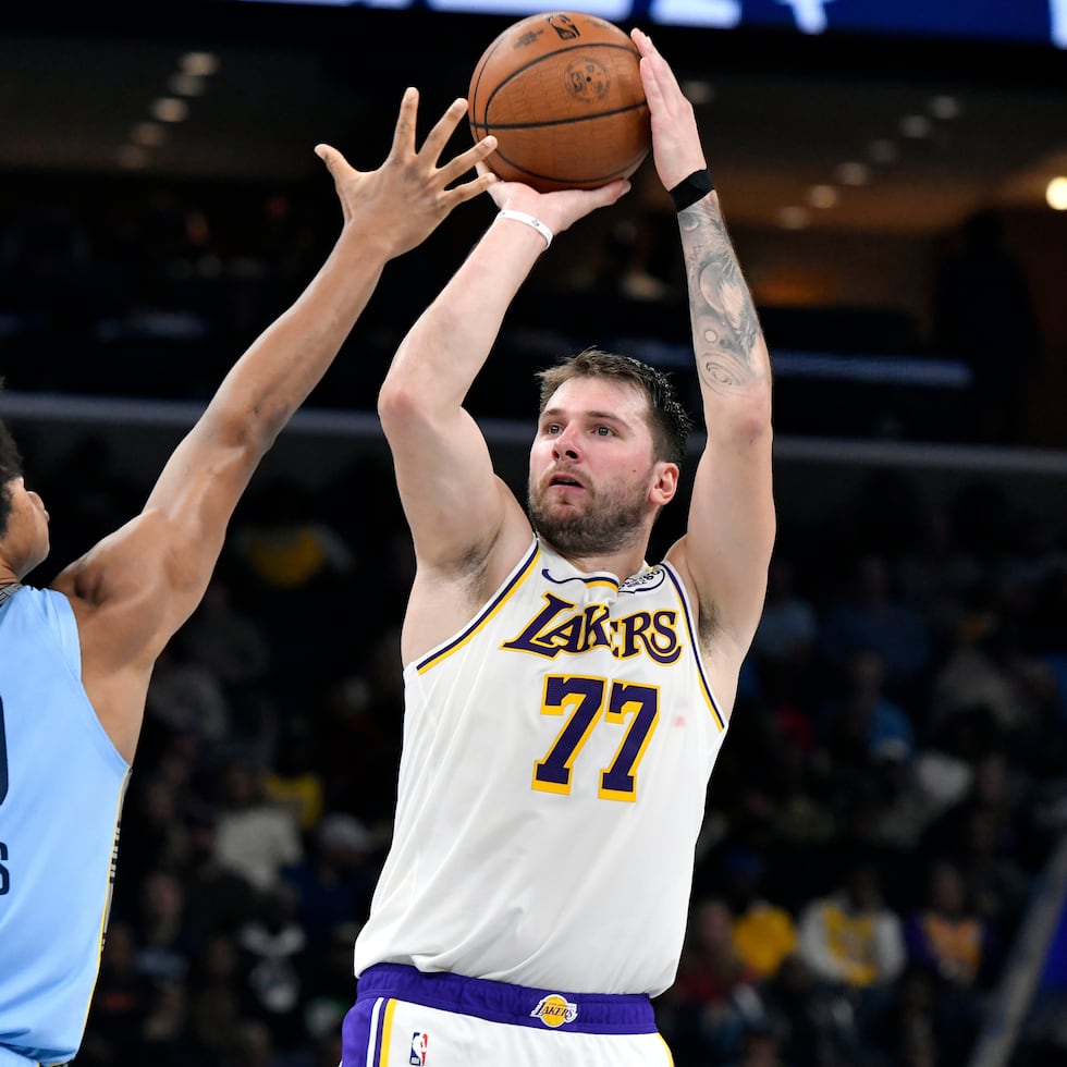 Luka Doncic, de los Lakers de Los Ángeles, toma un tiro frente a Jaylen Wells, de los Grizzlies de Memphis.