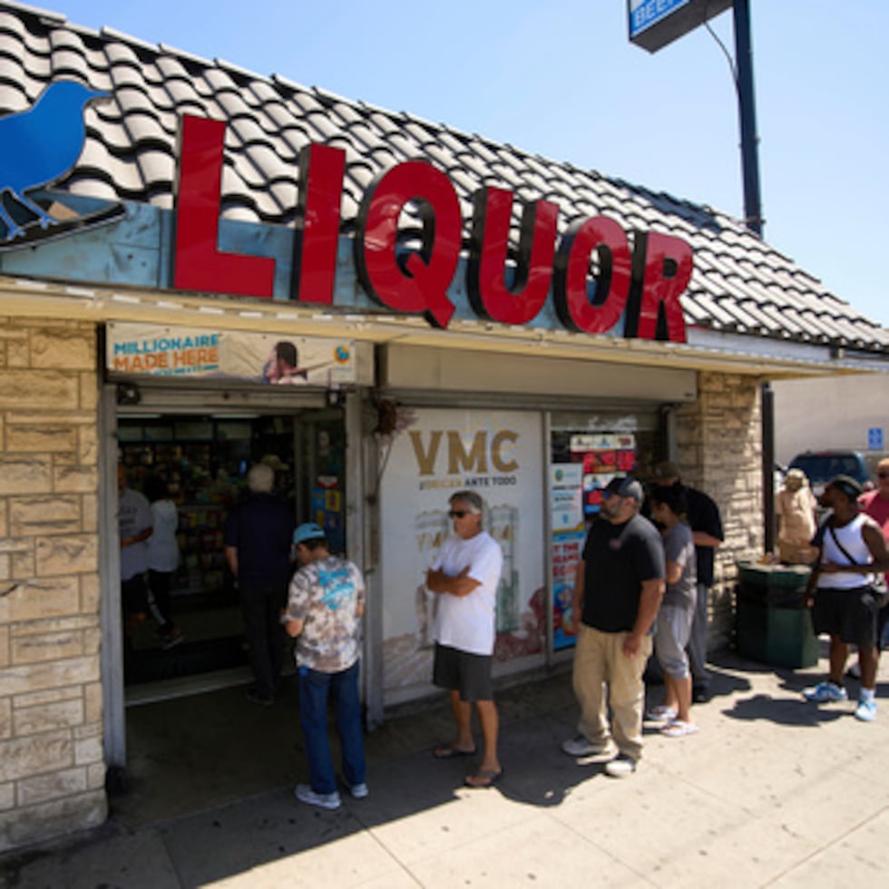 ARCHIVO - La gente espera en la cola para comprar billetes de lotería fuera de la tienda Bluebird Liquor en Hawthorne, California, el viernes 5 de septiembre de 2025. (AP Photo/Damian Dovarganes, Archivo)