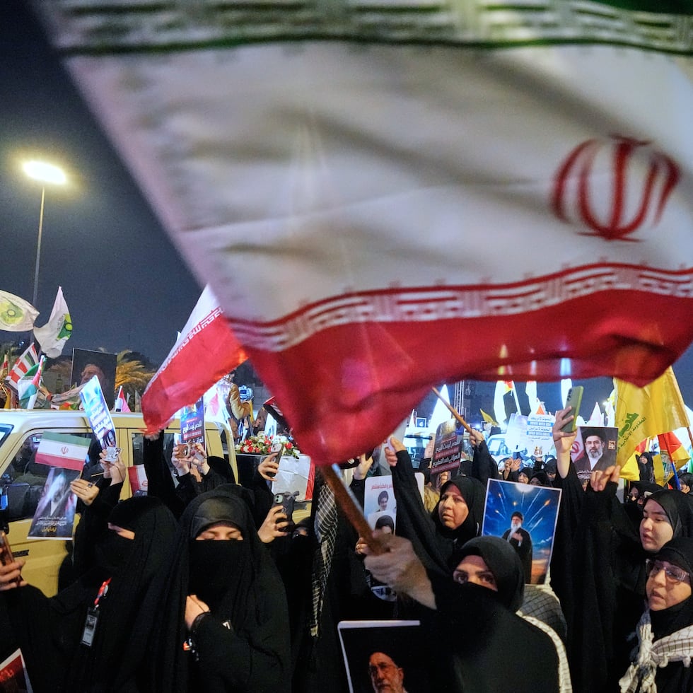 Mujeres musulmanas iraquíes ondean banderas iraníes y sostienen retratos del difunto líder de Irán, el ayatolá Alí Jamenei, y de su hijo, el ayatolá Mojtaba Jamenei.