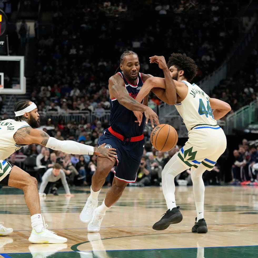 Kawhi Leonard, de los Clippers de Los Ángeles, se enfila hacia la canasta entre Gary Trent Jr. (5) y Andre Jackson Jr. (44), de los Bucks de Milwaukee.