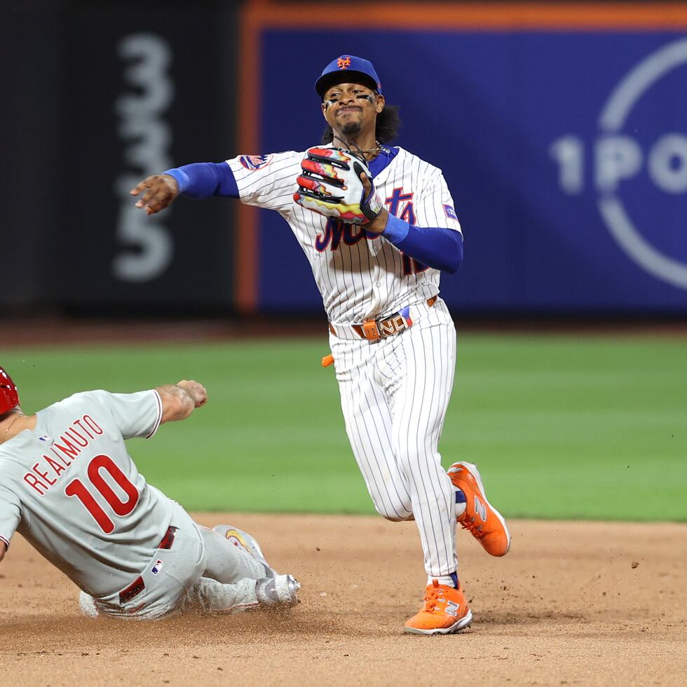 Francisco Lindor, lanza a la inicial luego de dar el out en segunda a J.T. Realmuto, de los Phillies de Filadelfia.