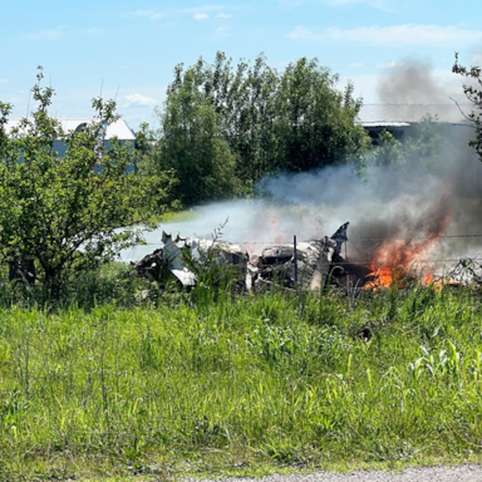 Los restos de un accidente aéreo arden en un campo de Butler, Misuri, el domingo 14 de junio.