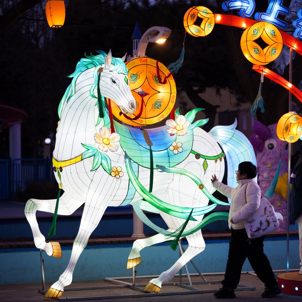 Visitantes pasan junto a la figura de un caballo iluminado antes de las celebraciones del Año Nuevo lunar en un parque de diversiones a las afueras de Beijing. El 17 de febrero de 2026 comienza el año del caballo en el calendario chino.