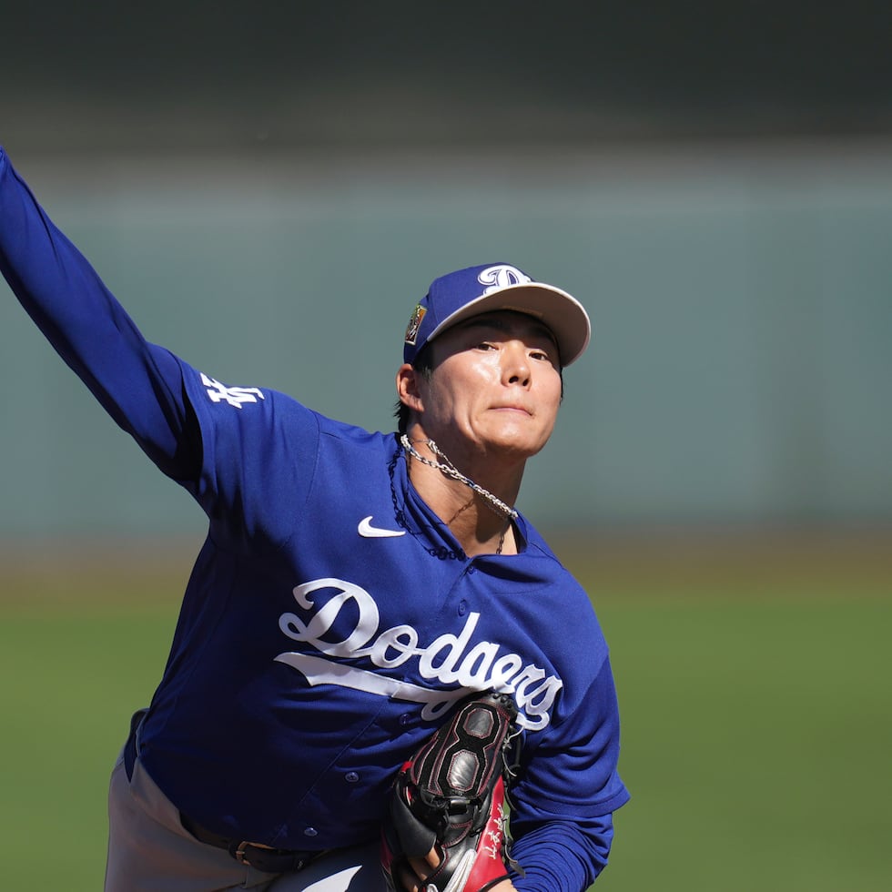 Yoshinobu Yamamoto, abridor de los Dodgers de Los Ángeles, realiza un lanzamiento durante la segunda entrada de un juego de los entrenamientos de primavera ante los Giants de San Francisco.