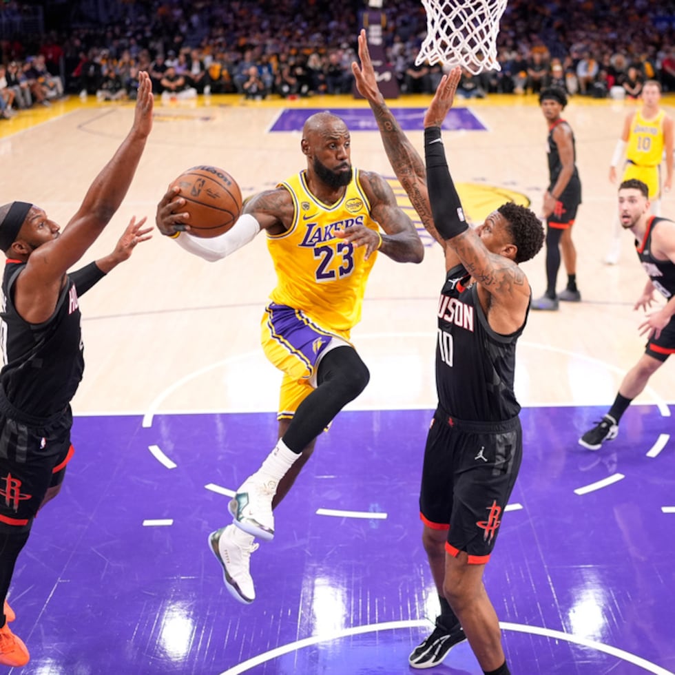 LeBron James elige pasa el balón ante la mirada de Josh Okogie, izquierda, y Jabari Smith Jr.
