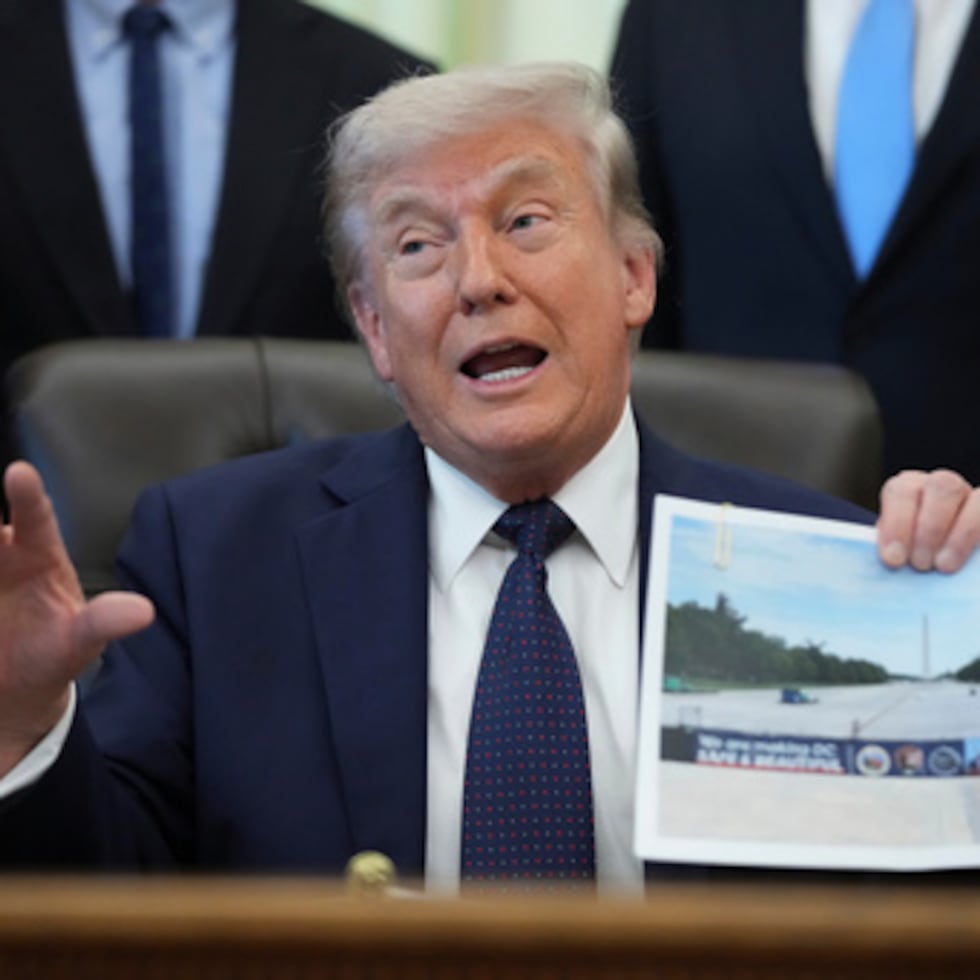 El presidente Donald Trump sostiene una foto del monumento durante un evento sobre la asequibilidad de la atención médica en la Oficina Oval de la Casa Blanca.