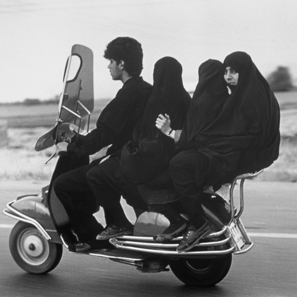 Un hombre transporta en su motocicleta a tres mujeres musulmanas en esta imagen del fotógrafo Abbas, miembro de Magnum Photos, tomada en Shahr Rey, Irán, en 1997.
