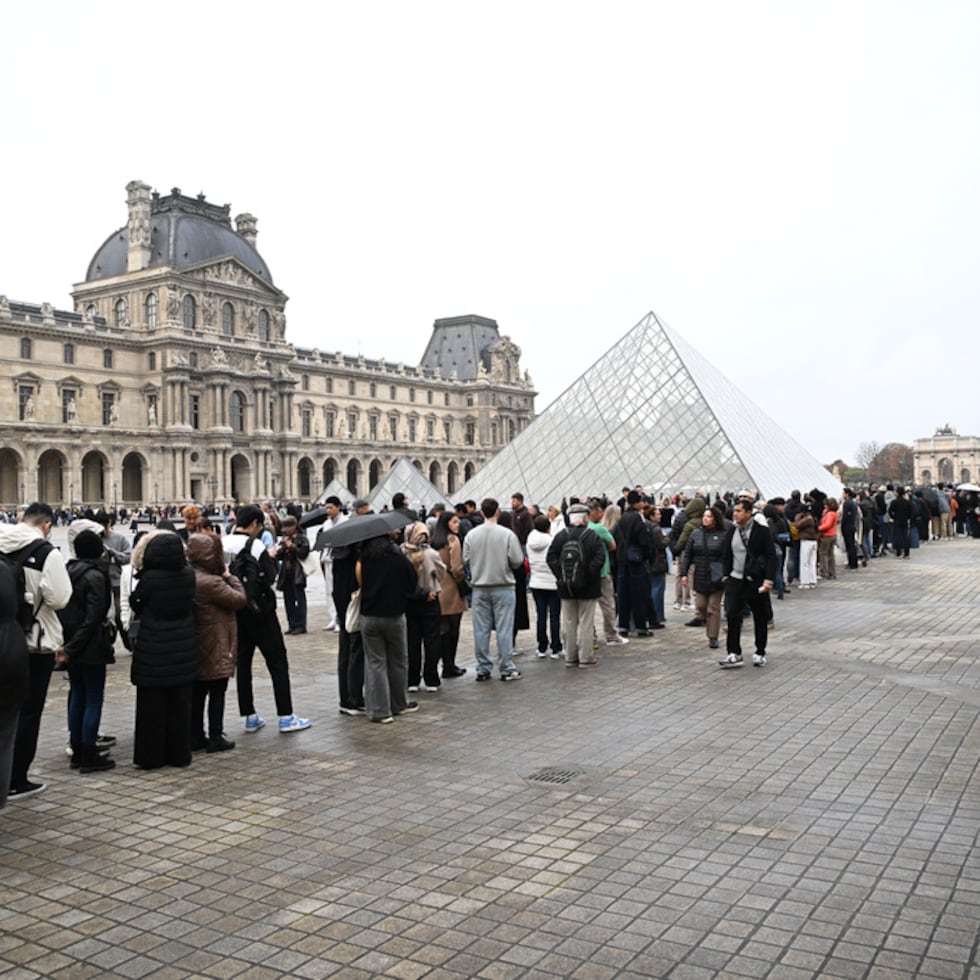 People queue outside the Louvre museum in Paris on Monday, Oct. 20, 2025, although it remains closed for the day after Sunday's jewels robbery. (AP Photo/Emma Da Silva)