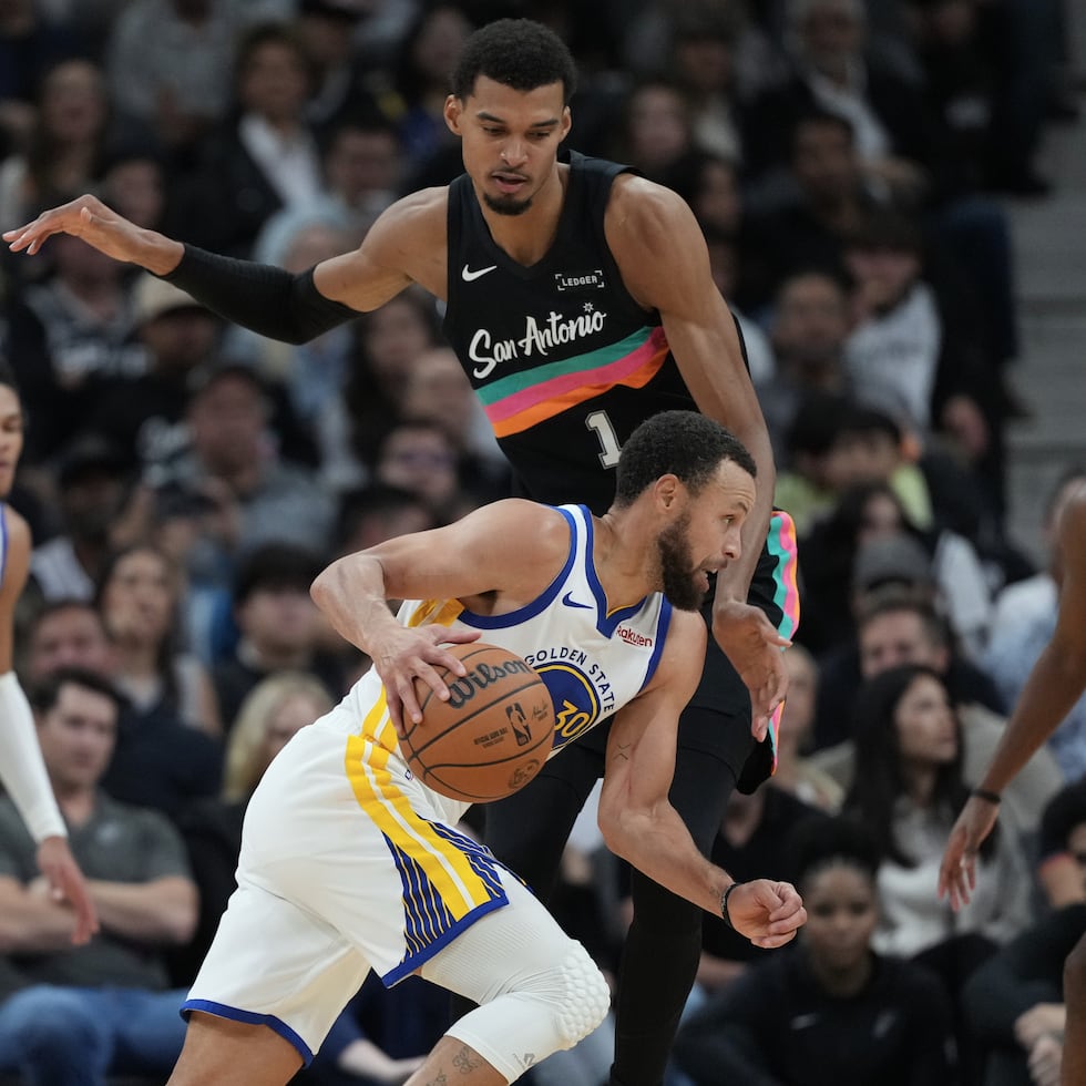 Stephen Curry (30), de los Warriors de Golden State, conduce el balón frente a Victor Wembanyama, de los Spurs de San Antonio.