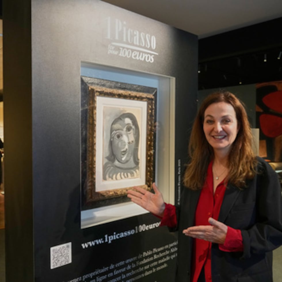 Peri Cochin, cofundadora de la lotería "1 Picasso por 100 euros", posa junto a Cabeza de mujer de Pablo Picasso, pintada en 1941, en París, el viernes 10 de abril de 2026, donde la casa de subastas Christie's se encargará del sorteo la próxima semana. (AP Photo/Michel Euler)