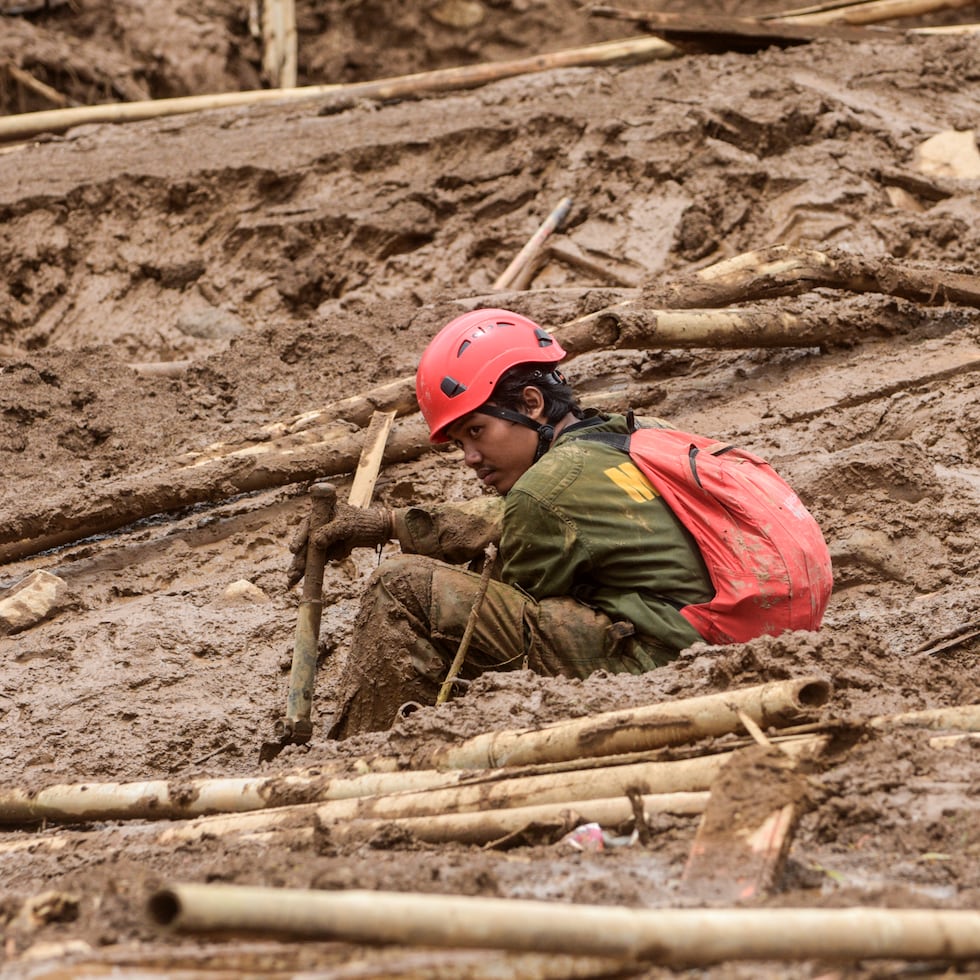 Decenas de familiares sin noticias de sus allegados esperaban angustiados este lunes cerca del pueblo de Pasirlangu, a 25 km al noroeste de Bandung, uno de los dos parcialmente sepultados por el enorme deslizamiento causado por lluvias torrenciales. (Photo by Timur Matahari / AFP)